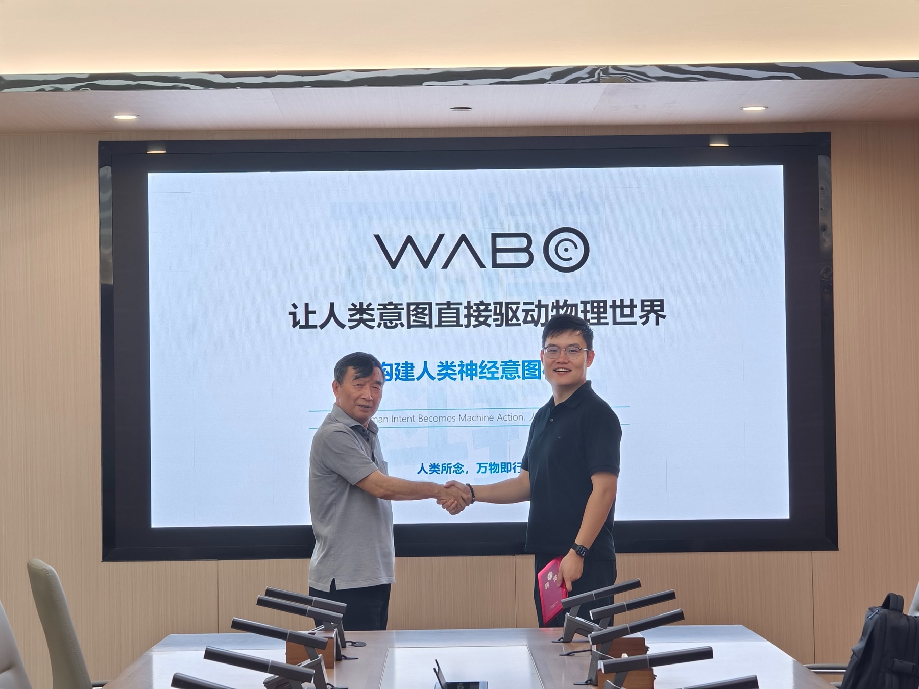 Professor Jianwu Dang and WABO founder Zhang Xingzhi shake hands at WABO.